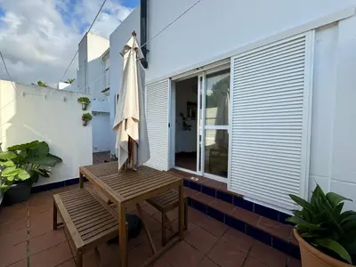 a patio with a table and an umbrella on a balcony at Adosado en Novo Sancti Petri in Novo Sancti Petri