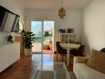 a living room with a white couch and a table at Adosado en Novo Sancti Petri in Novo Sancti Petri
