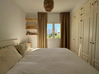 a bedroom with a large bed and a window at Adosado en Novo Sancti Petri in Novo Sancti Petri