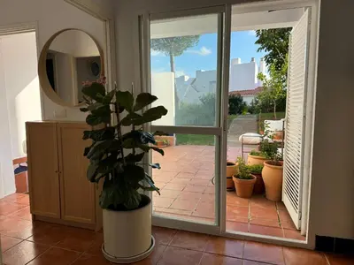 a potted plant in front of a sliding glass door at Adosado en Novo Sancti Petri in Novo Sancti Petri
