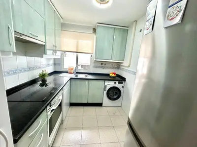 a kitchen with blue cabinets and a refrigerator at Gatu VILLA ANTILLAS parking gratis preferentemente mayores de 25 años y familias in El Puerto de Santa María