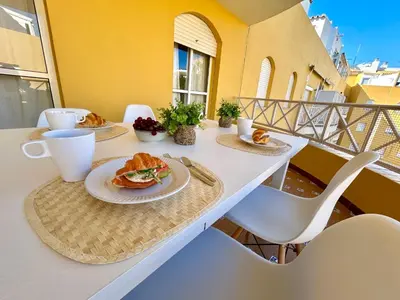 a table with plates of food on a balcony at Gatu VILLA ANTILLAS parking gratis preferentemente mayores de 25 años y familias in El Puerto de Santa María