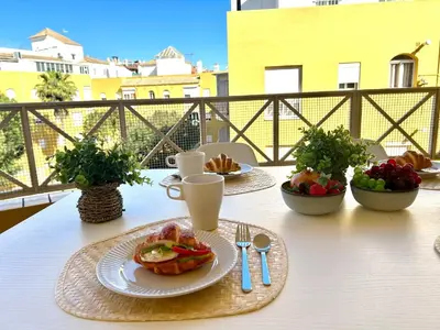 a table with plates of food on top of a balcony at Gatu VILLA ANTILLAS parking gratis preferentemente mayores de 25 años y familias in El Puerto de Santa María