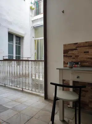 a table and a chair on a balcony at Old Merchant's Home in Cádiz