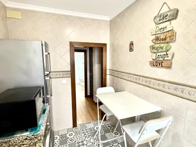 a kitchen with a table and a refrigerator at Los 3 hermanos by Staycare in Rota
