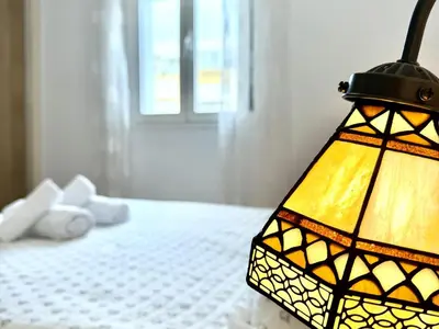 a bedroom with a bed with a lamp on it at Los 3 hermanos by Staycare in Rota