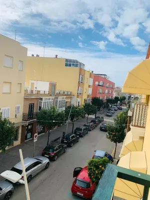 a city street with cars parked in a parking lot at Chipiona Center in Chipiona