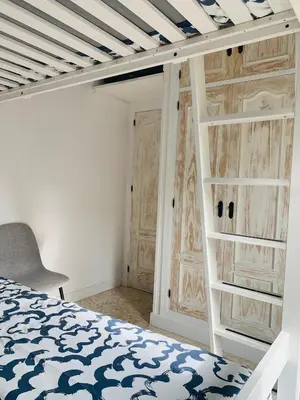 a bedroom with a bed and a ladder and a closet at Chipiona Center in Chipiona
