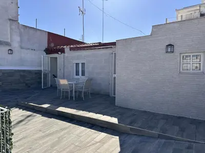 a patio with a table and chairs next to a building at Dante Suite - Ole Solutions in Jerez de la Frontera