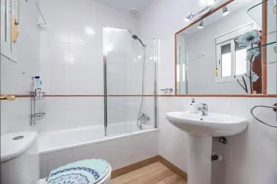a white bathroom with a sink and a shower at Apartamento Turístico en Chiclana de la Frontera in Chiclana de la Frontera