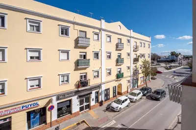 an apartment building with cars parked in front of it at Apartamento Turístico en Chiclana de la Frontera in Chiclana de la Frontera