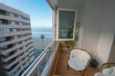 a balcony with a window with a view of the ocean at Alta Mar Playa Victoria in Cádiz