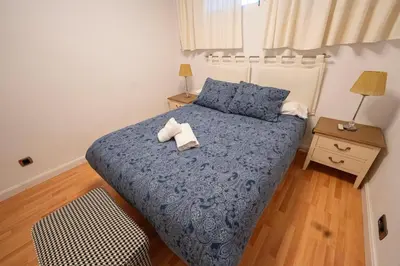 a bedroom with a blue bed with two towels on it at Alta Mar Playa Victoria in Cádiz
