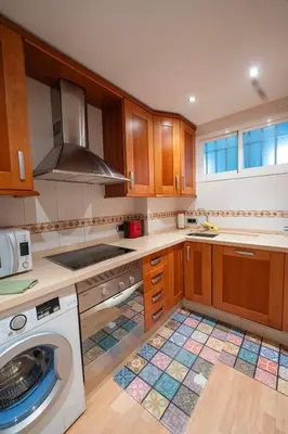 a kitchen with a washer and a washing machine at Alta Mar Playa Victoria in Cádiz