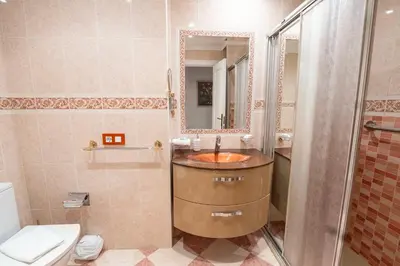 a bathroom with a sink and a toilet and a mirror at Alta Mar Playa Victoria in Cádiz