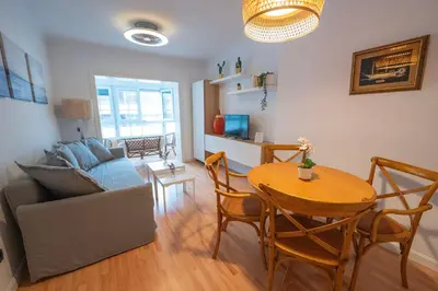 a living room with a table and a couch at Alta Mar Playa Victoria in Cádiz