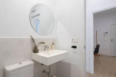 a white bathroom with a sink and a mirror at Apartoyou - El Patio Centro in El Puerto de Santa María