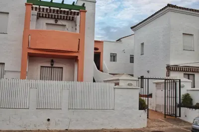 a white fence in front of a white building at Apartamento Familiar junto a Playa La Barrosa in Novo Sancti Petri