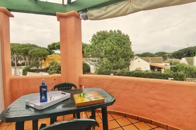 a table and chairs on a balcony with a view at Apartamento Familiar junto a Playa La Barrosa in Novo Sancti Petri