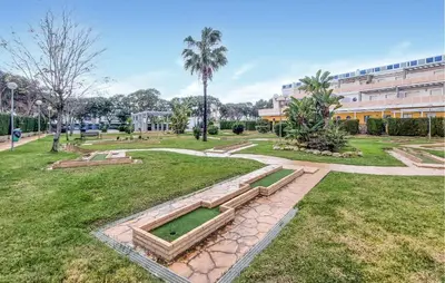 a park with benches and a building in the background at 4 Bedroom Awesome Apartment In Chipiona in Chipiona