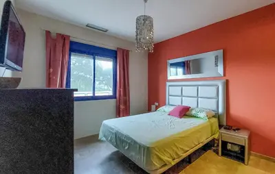 a bedroom with a bed with an orange wall at 4 Bedroom Awesome Apartment In Chipiona in Chipiona
