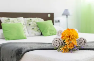 a bed with towels and a bouquet of flowers on it at Apartments Vistas Mar Bahia in Cádiz