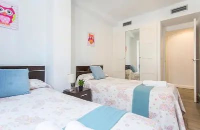 a bedroom with two beds and a mirror at Apartments Vistas Mar Bahia in Cádiz