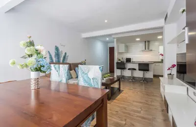 a kitchen and living room with a wooden table at Apartments Vistas Mar Bahia in Cádiz
