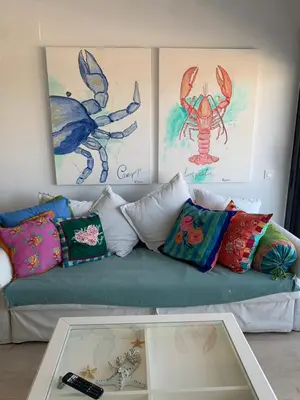 a couch with colorful pillows and paintings on the wall at Arenas de Doñana in Sanlúcar de Barrameda