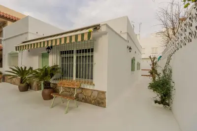 a white house with a bench in front of it at Villa Emilia in Sanlúcar de Barrameda