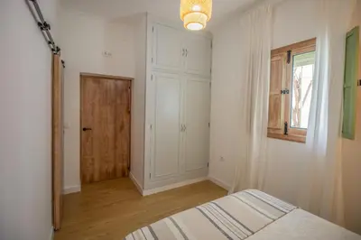 a bedroom with a bed and a window and a door at Villa Emilia in Sanlúcar de Barrameda