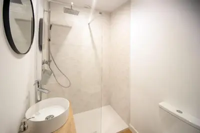 a white bathroom with a sink and a shower at Villa Emilia in Sanlúcar de Barrameda