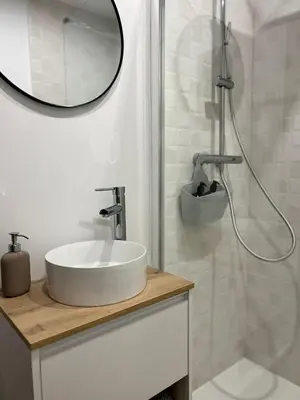 a white bathroom with a sink and a mirror at Villa Emilia in Sanlúcar de Barrameda