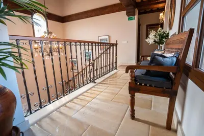 a hallway with a wooden railing and a chair at Hotel Azalea Playa in Chiclana de la Frontera