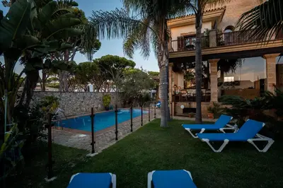 a resort yard with chairs and a swimming pool at Hotel Azalea Playa in Chiclana de la Frontera