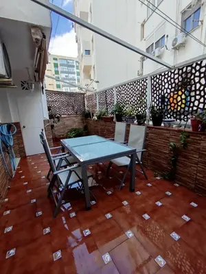 a table and chairs on an outdoor patio at Ave 26, piso junto playa in Cádiz
