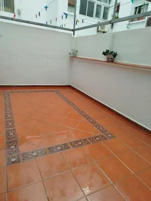 a room with a tile floor and a white wall at Ave 26, piso junto playa in Cádiz