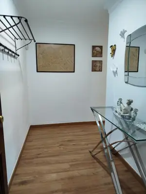 a glass table in front of a white wall at Ave 26, piso junto playa in Cádiz