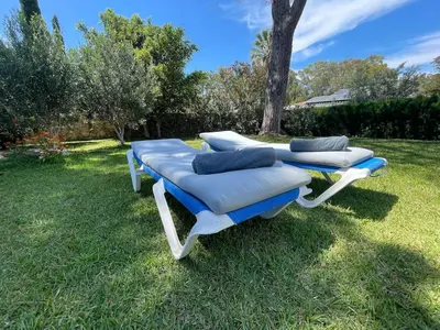 three lounge chairs sitting on the grass in a yard at Casa 77, la playa más bonita a 150 metros in Conil de la Frontera