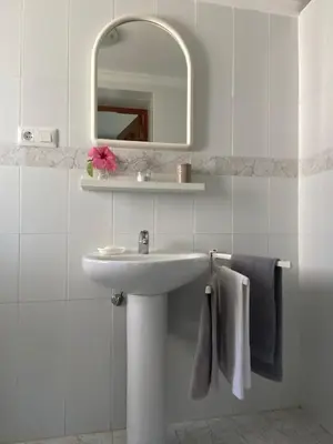 a bathroom with a sink and a mirror and towels at Casa 77, la playa más bonita a 150 metros in Conil de la Frontera