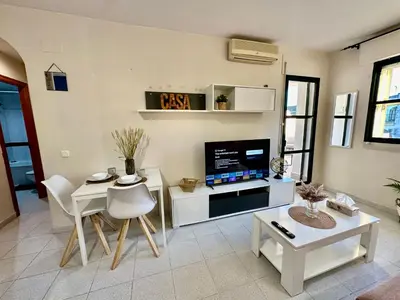 a living room with a tv and a table and chairs at Piso Bahia in Chiclana de la Frontera