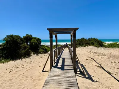 a wooden boardwalk on a beach with the ocean at Piso Bahia in Chiclana de la Frontera