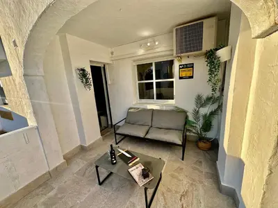 a living room with a chair and a table at Piso Bahia in Chiclana de la Frontera