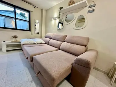 a living room with a couch and some windows at Piso Bahia in Chiclana de la Frontera