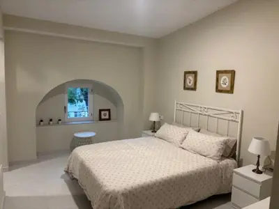 a white bedroom with a bed and a window at Apartamento la Porvera in Jerez de la Frontera