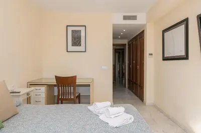 a bedroom with a bed and a desk and a chair at Bajamar Deluxe in El Puerto de Santa María