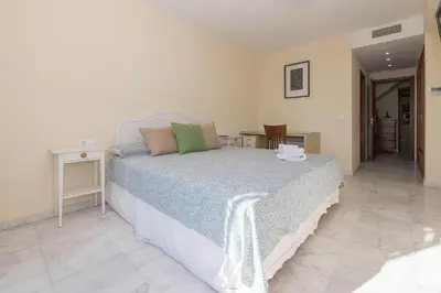 a bedroom with a bed and a table and a chair at Bajamar Deluxe in El Puerto de Santa María