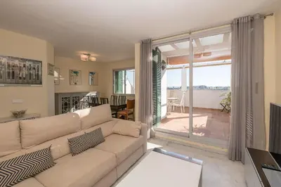 a living room with a couch and a view of a patio at Bajamar Deluxe in El Puerto de Santa María