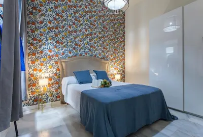 a bedroom with a bed with a floral wall at Catedral Moderno Centro in Jerez de la Frontera