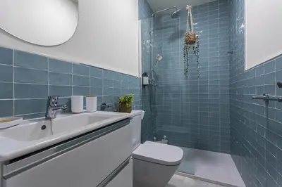 a bathroom with a sink and a toilet and blue tiles at Catedral Moderno Centro in Jerez de la Frontera